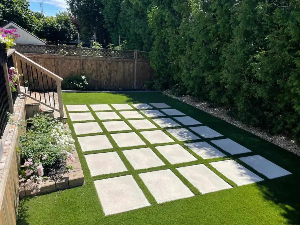 A lush residential lawn with stepping stones and planted garden borders